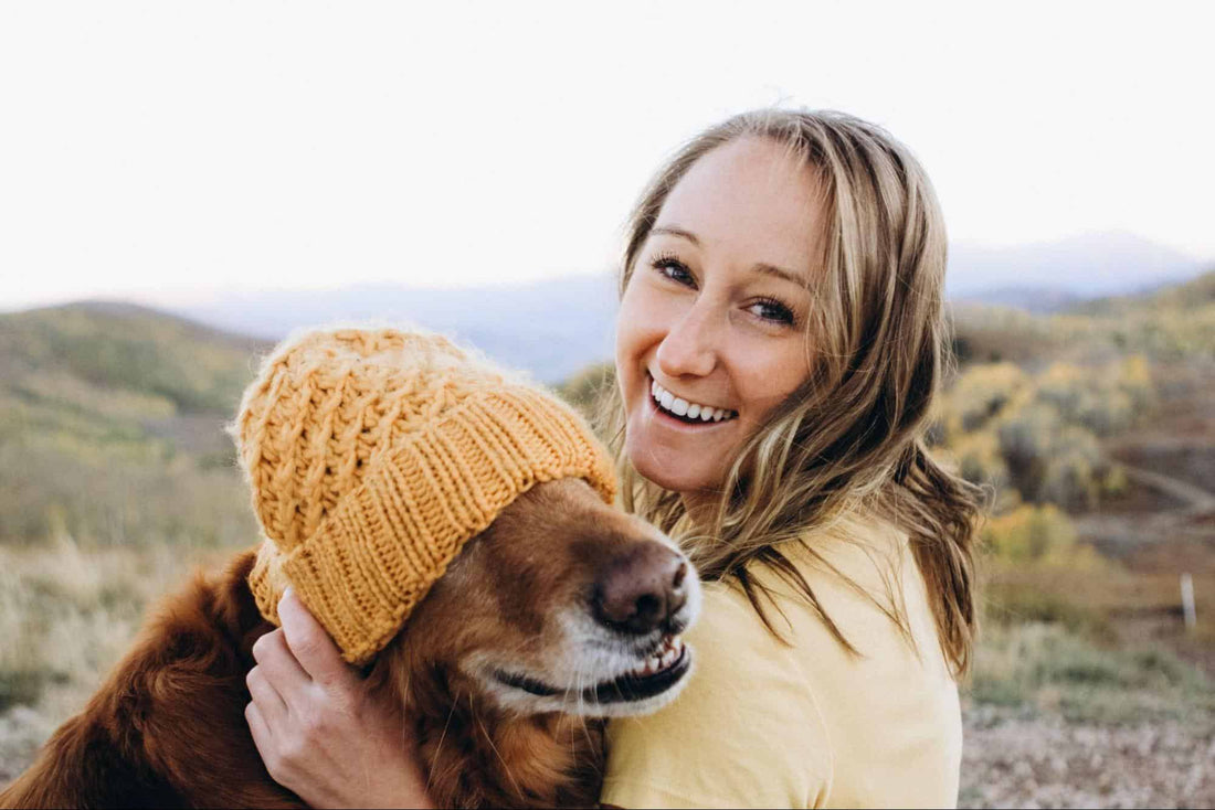 a woman with her dog wearing a beanie cap