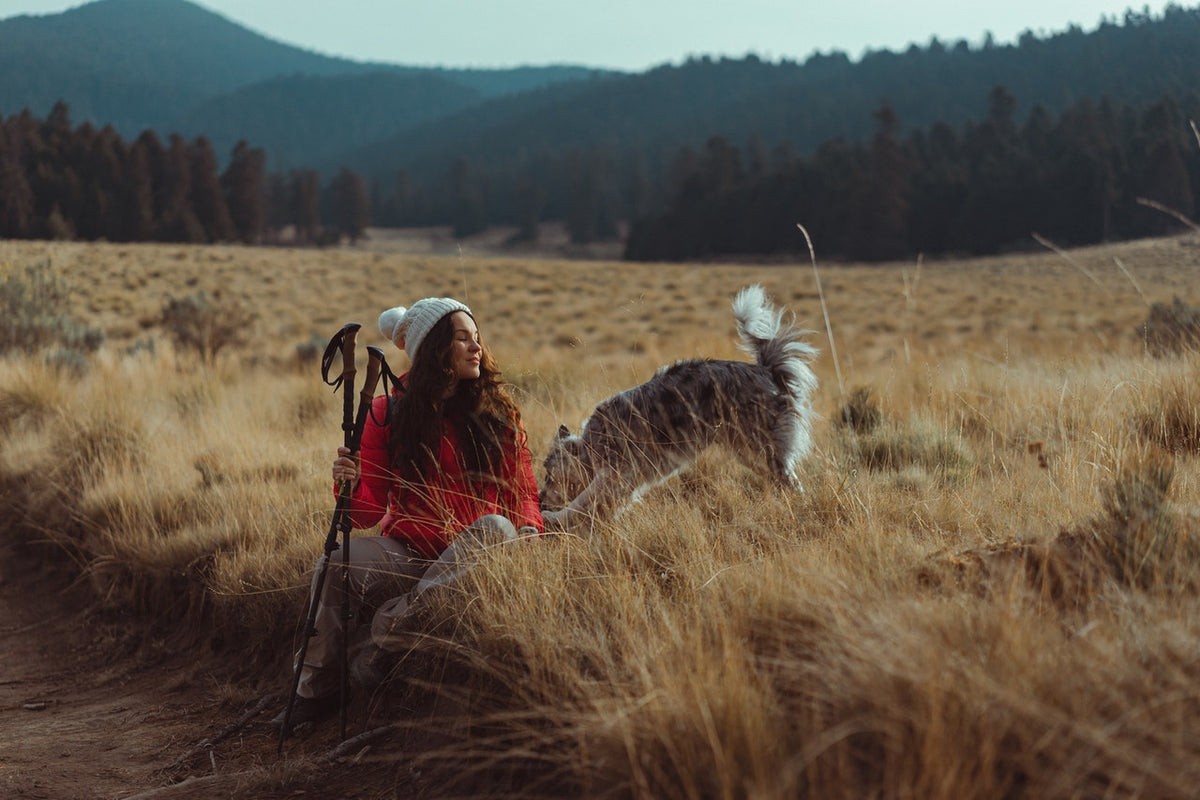 Woman on a hiking trail with her dog. 